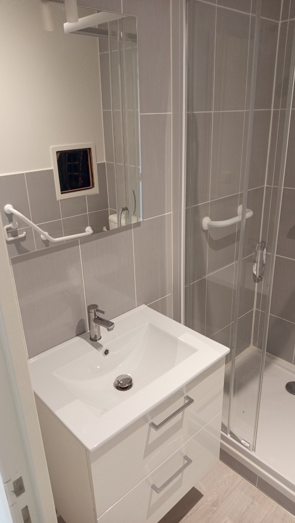 Installation d'un meuble vasque suspendu 2 tiroirs blanc laqué avec mitigeur chromé et miroir de salle de bain par un plombier qualifié